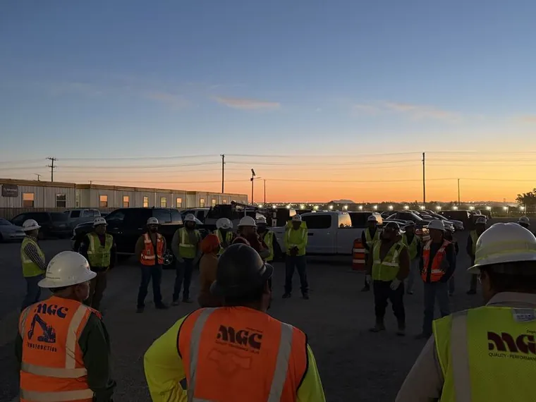 Construction workers at a dawn safety briefing during the heat and ozone field pilot at El Paso Water’s Bustamonte plant.