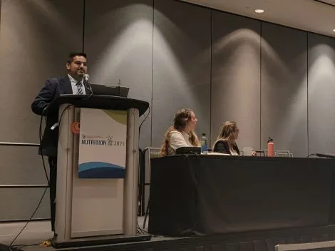 Dr. Aguilera presenting produce-prescription evaluation methods at the Nutrition 2025 podium.