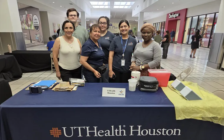Six members of the CHIP field team behind a UTHealth Houston School of Public Health screening table at a community event.